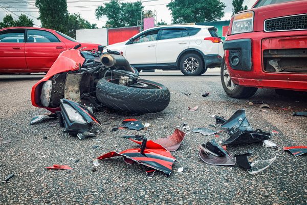 Motorcycle bike accident and car crash, broken and wrecked moto on road